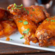 Chicken wings on white plate on wooden tabletop